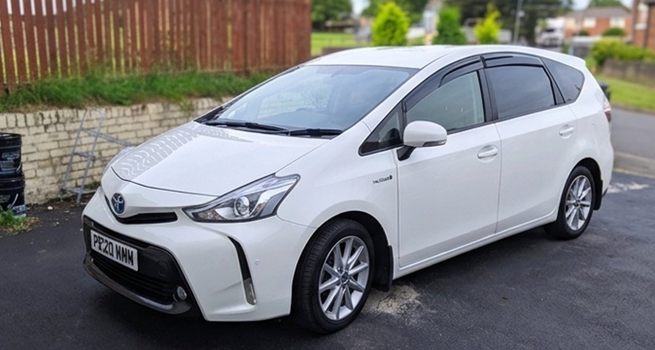 White Toyota Prius+ hybrid taxi, front three-quarter view