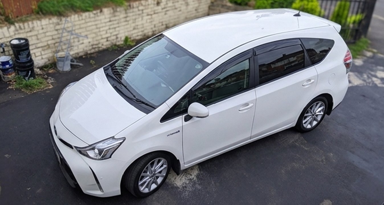 White Toyota Prius+ hybrid taxi, top-down side view
