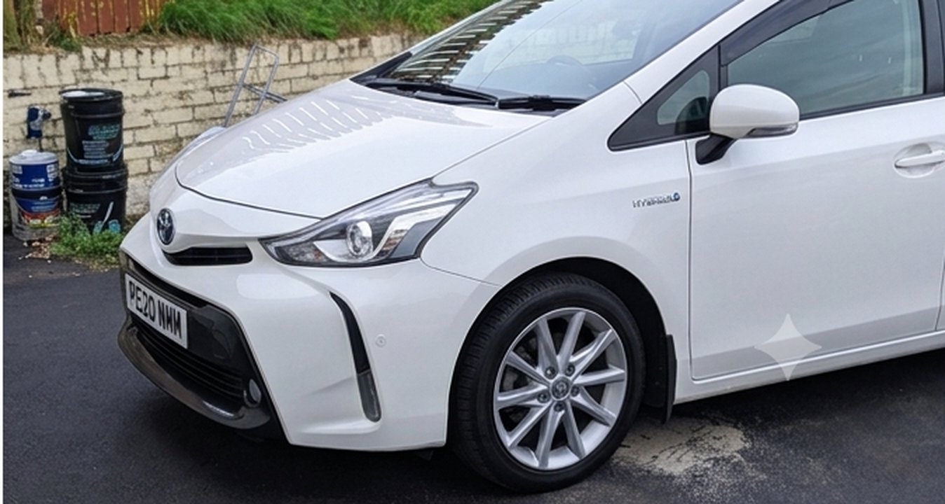 White Toyota Prius+ hybrid taxi, front close angle